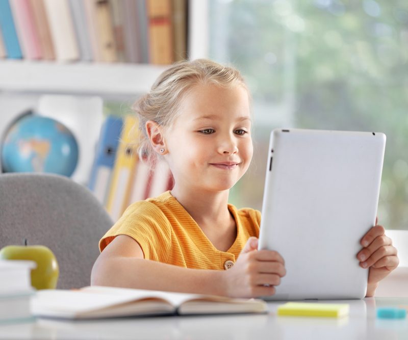 Young girl using a tablet while experiencing symptoms related to convergence insufficiency