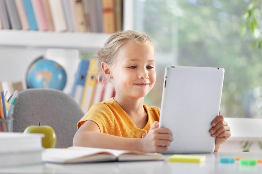 Young girl using a tablet while experiencing symptoms related to convergence insufficiency
