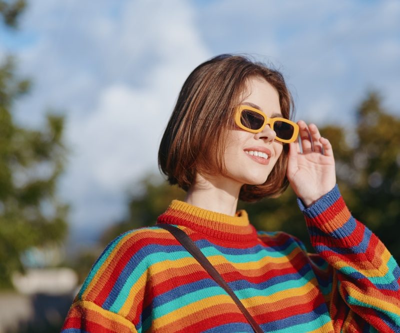 Woman wearing sunglasses outdoors to help protect against photokeratitis caused by UV exposure