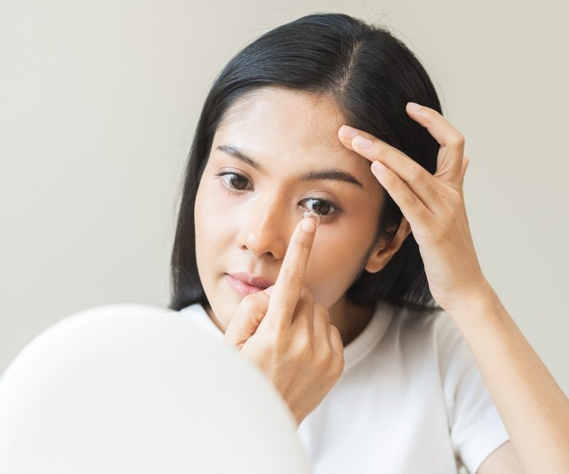 Patient applying contact lenses for dry eye treatment at Optical Solutions in Hilton Head Island and Bluffton, SC
