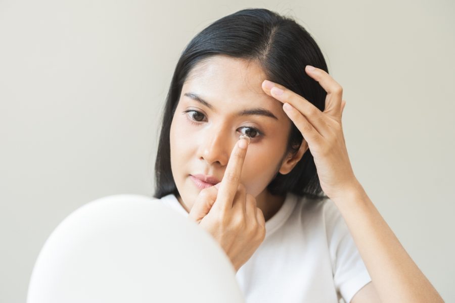 Patient applying contact lenses for dry eye treatment at Optical Solutions in Hilton Head Island and Bluffton, SC